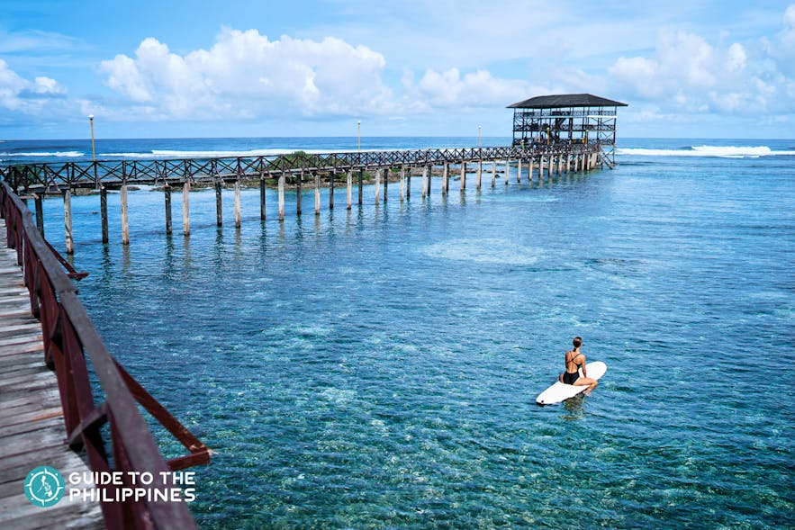 Girl surfing at Cloud 9, Siargao Island, Philippines 