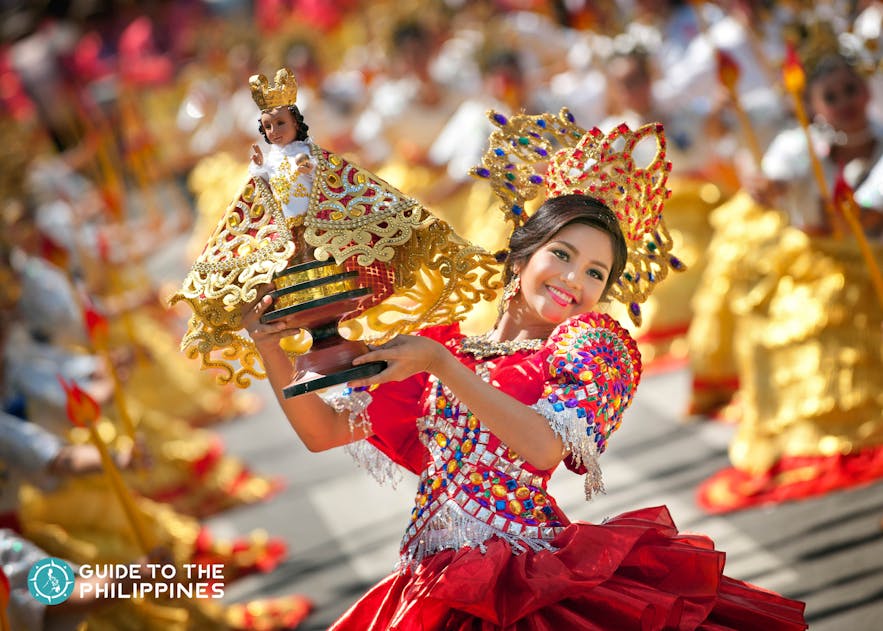 Street performer holding a Sto. Niño during Sinulog festival