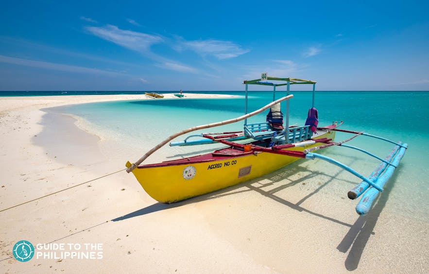 Boat docked on the shores of White Island in Camiguin