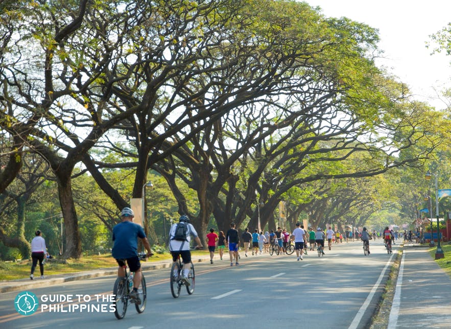 人们在菲律宾迪里曼大学绕 Academic Oval 骑行