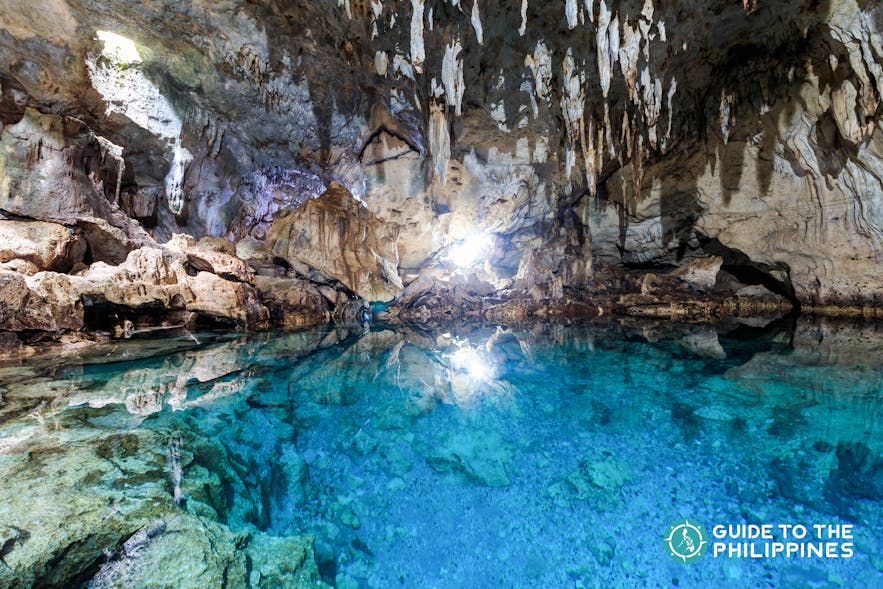 Hinagdanan Cave features a pool of clear water at the bottom