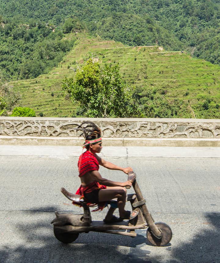 Ifugaos on their wooden scooters in Banaue, Philippines