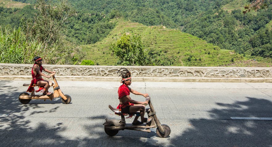 Ifugaos on their wooden scooters in Banaue, Philippines