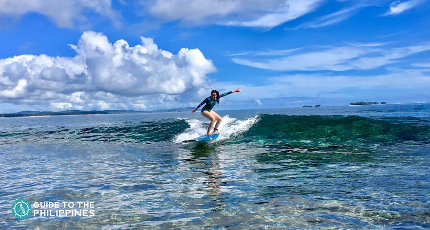 Surfer riding the waves of Cloud 9, Siargao