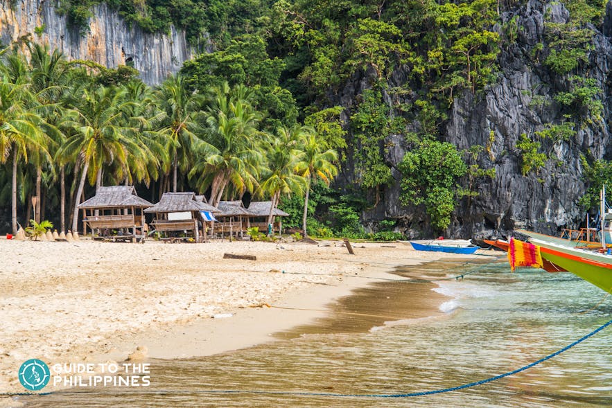 Cottages and boats docked in Seven Commandos Beach in El Nido, Palawan