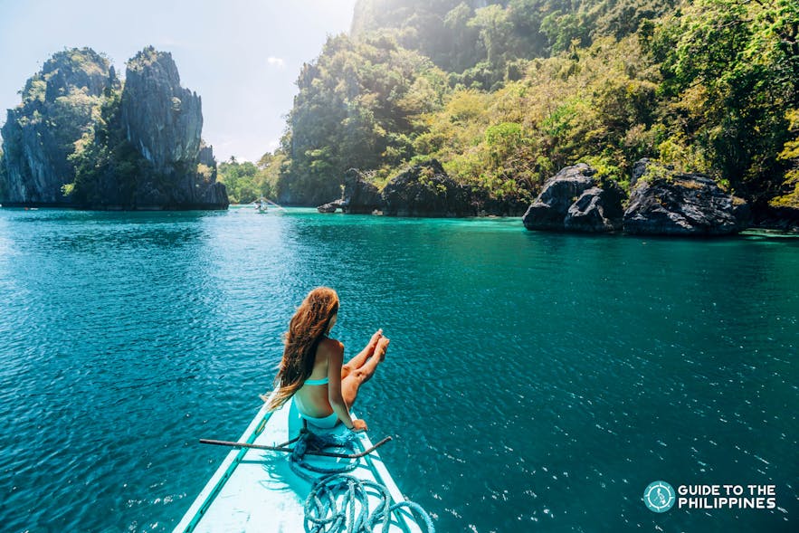 Traveler on the tip of a boat in Palawan