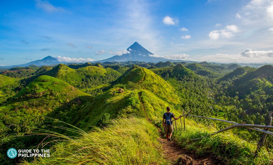 Hiker at Quitinday Hills overlooking Mt. Mayon in Legazpi, Albay, Philippines