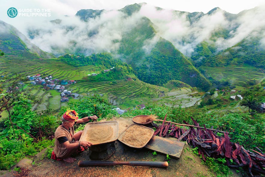 Old woman in traditional tribal clothes overlooking Banaue Rice Terraces