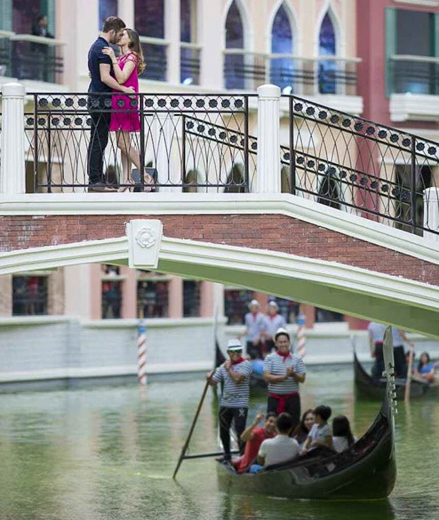 Couple kissing at the bridge over the Venice Grand Canal Mall