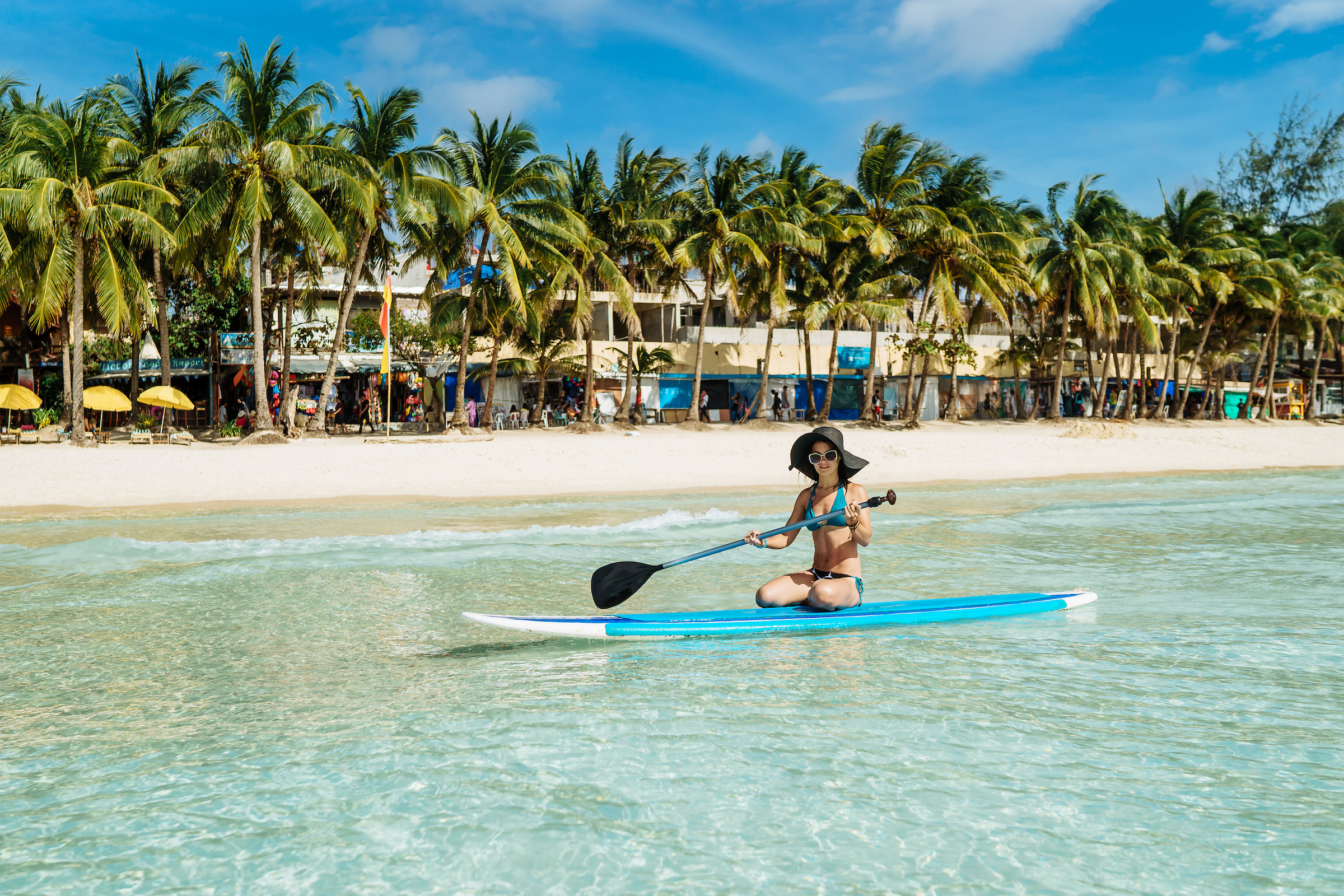 A tourist trying to get the hang of paddle boarding in Boracay
