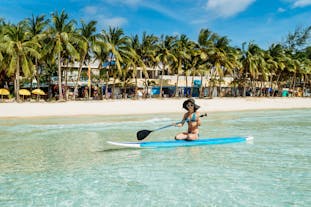 A tourist trying to get the hang of paddle boarding in Boracay