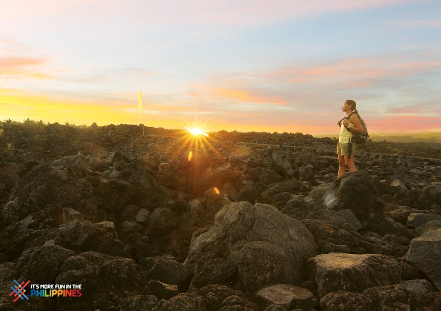 A girl hiking Mayon Volcano during sunset