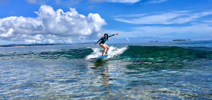 Girl surfing at Siargao surf spot