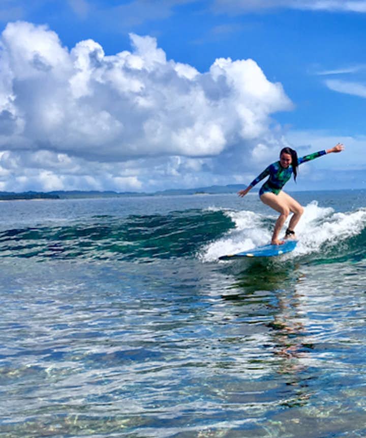 Girl surfing at Siargao surf spot