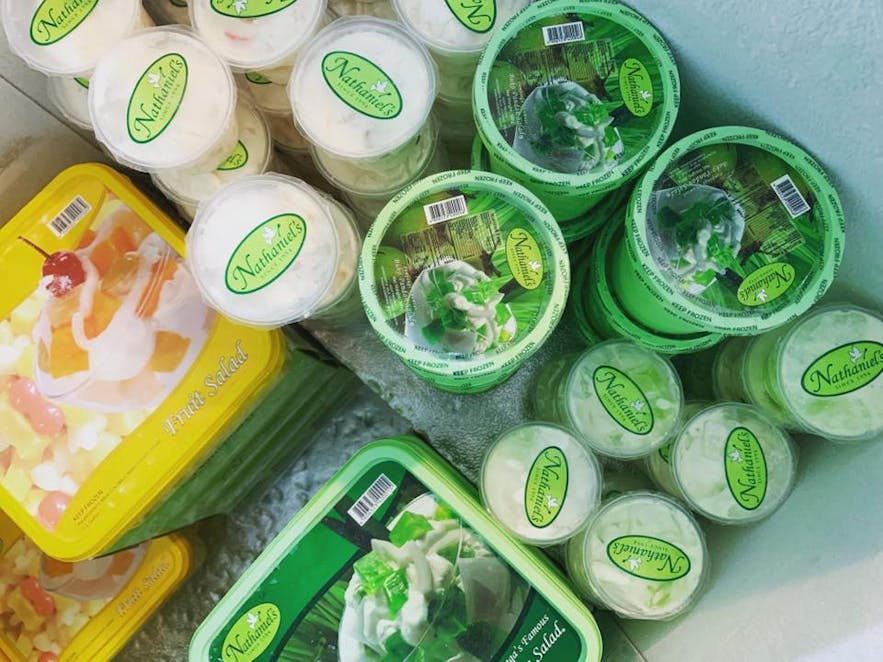 Containers of buko pandan and fruit salad in a freezer