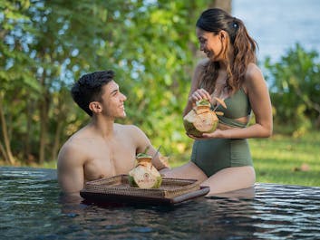 Couple enjoying coconut drink at one of the pools of Amorita Resort