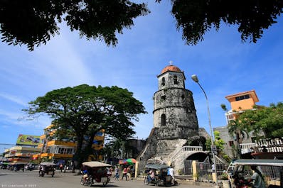 Vehicles passing by the Belfry Tower in Dumaguete