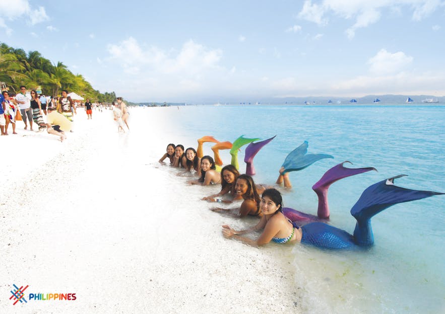 Several tourists taking a photo while wearing their mermaid costume in Boracay
