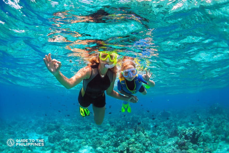 Two tourists snorkeling in the clear blue waters of Boracay