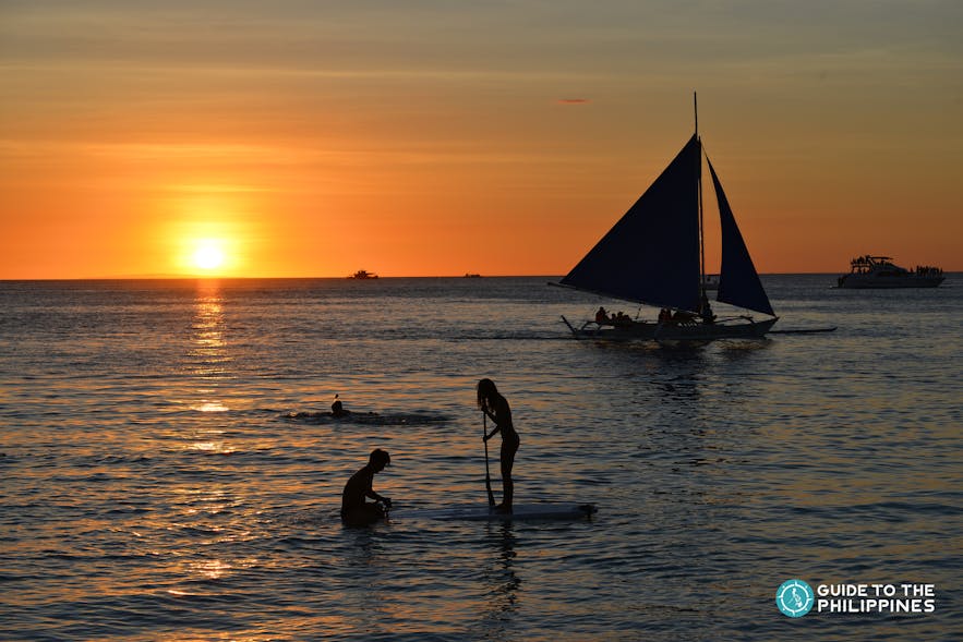 Paraw sailing and paddleboarding in Boracay during sunset