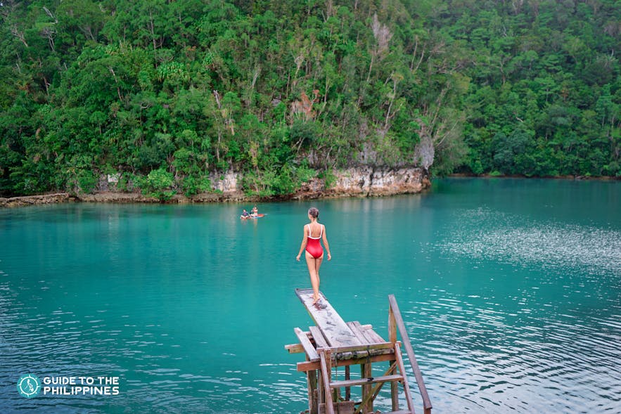 A girl about to jump from a diving board in Sugba Lagoon