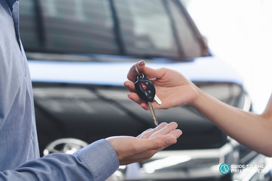 Car rental company handing over the keys to a customer