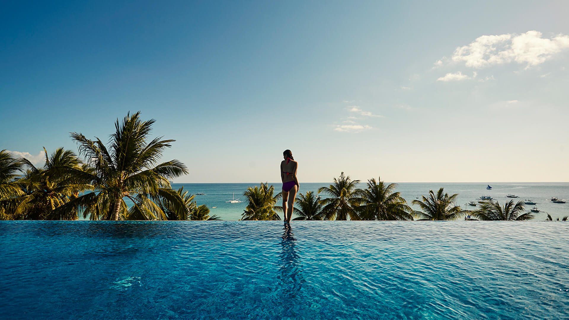A girl looking at the sea from the pool area of The Lind