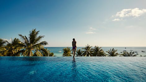 A girl looking at the sea from the pool area of The Lind