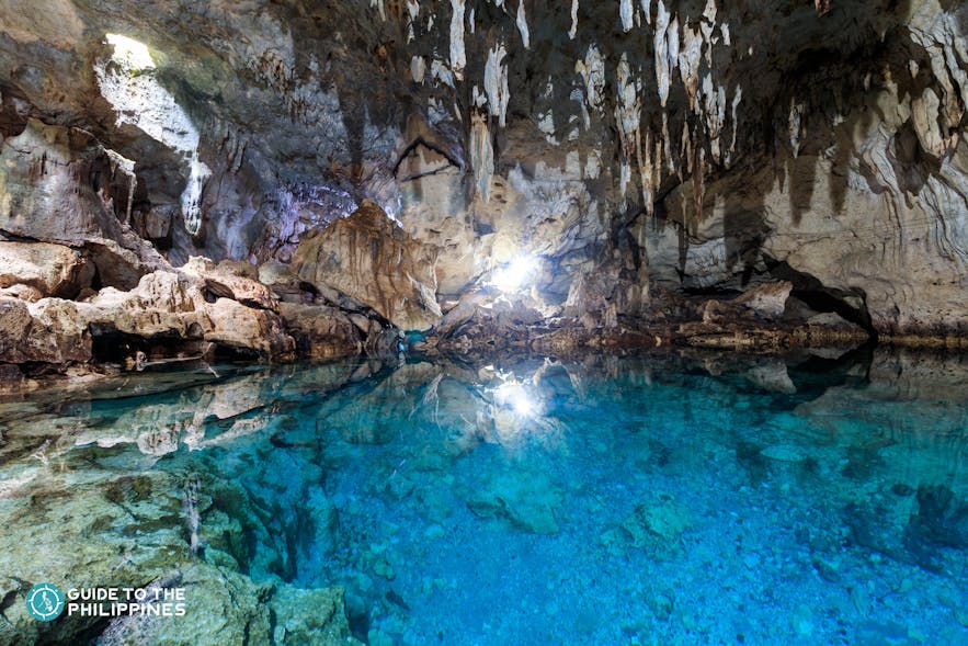 Sparkling blue pool inside Hinagdanan Cave