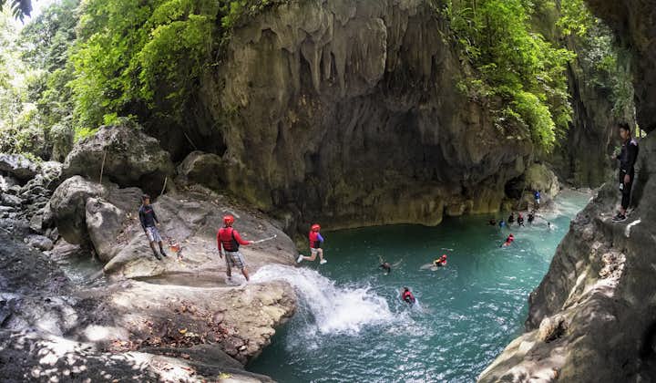Tourists jumping during the Canyoneering experience at Kawasan Falls