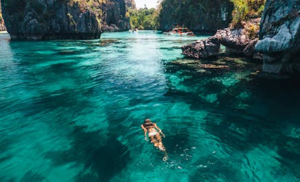 A girl floating on the waters of Big Lagoon in El Nido Palawan