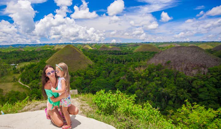 Mother and daughter taking a photo at Chocolate Hills in Bohol