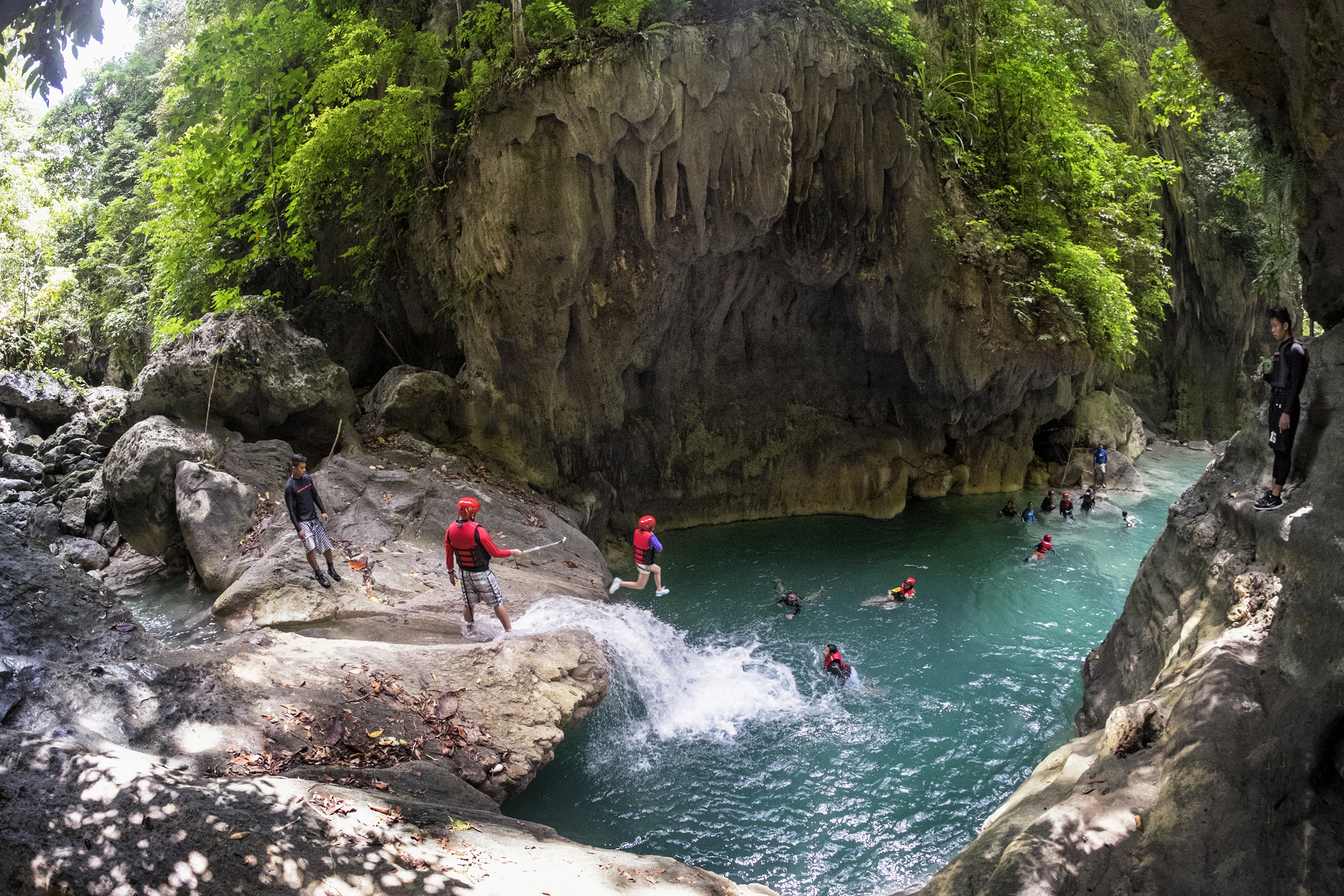 Tourists jumping in the waters of Kawasan Falls