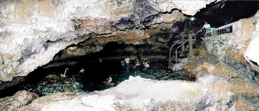 Guest swim in a natural pool inside the Enchanted Cave