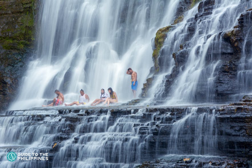 People relaxing under the Merloquet Falls