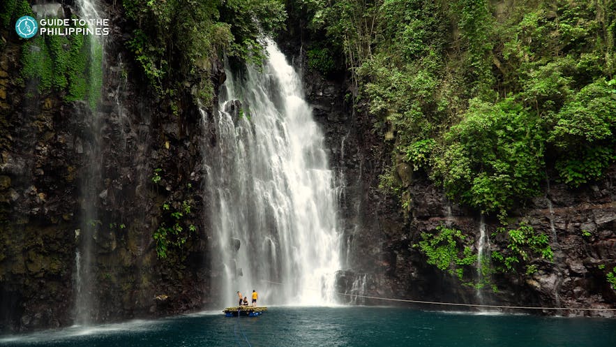 People standing on raft by Tinago Falls in Iligan City