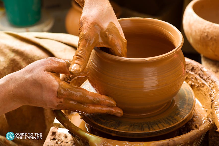 Woman molding a clay pot