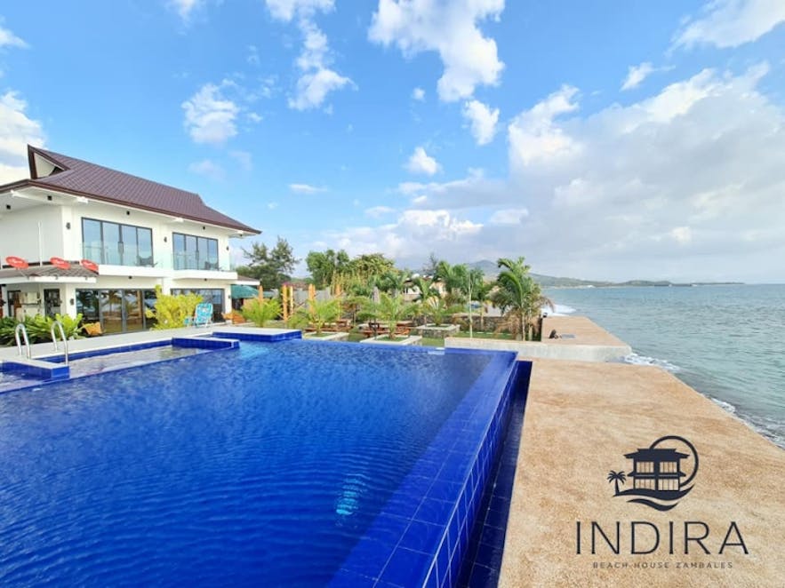 The pool and beachfront of Indira Beach House