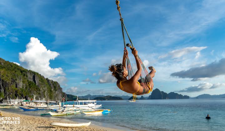 A woman swinging at Seven Commandos Beach in El Nido Palawan
