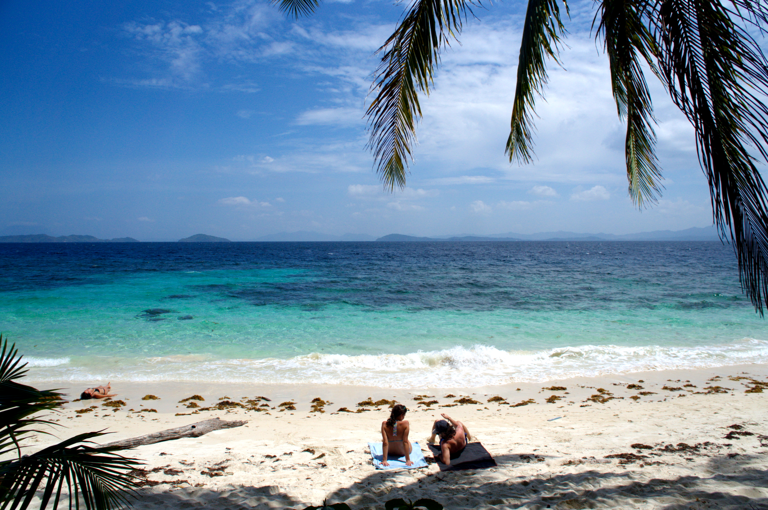 Two people enjoying a beach in Port Barton Palawan