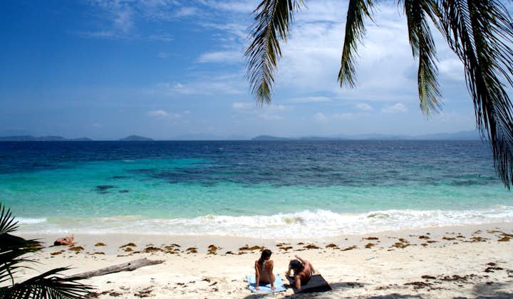 Two people enjoying a beach in Port Barton Palawan
