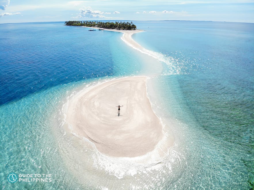 Tourist stands on Kalanggaman Island's sandbar