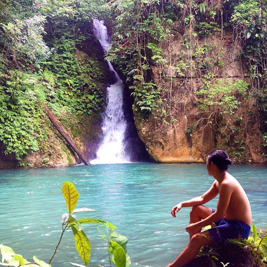Man sitting by the Sapang Blue Falls