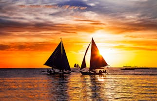 Silhouette of Paraw Sailing Boats at Sunset in Boracay Island