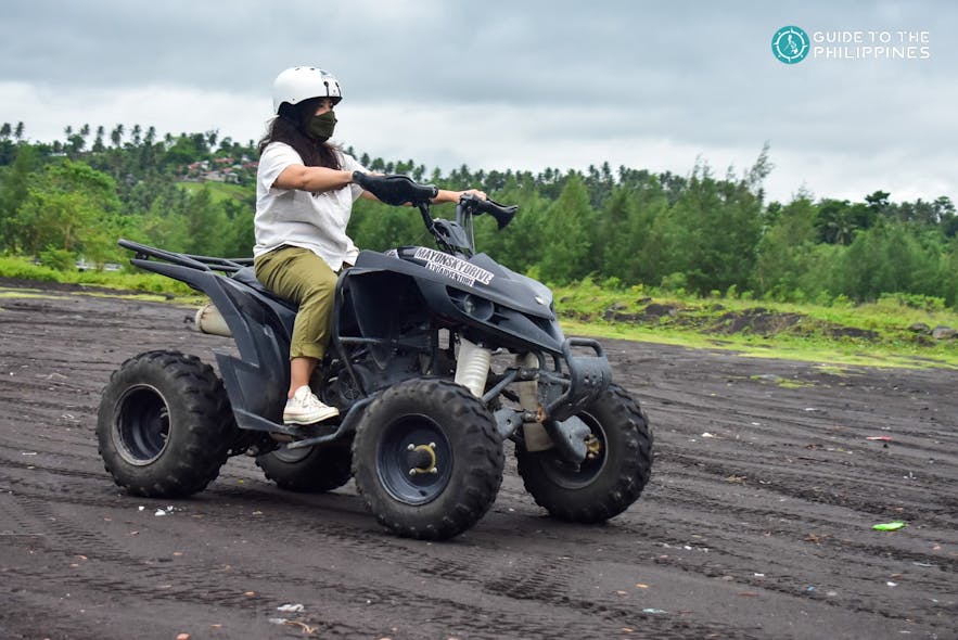 Woman driving an ATV on a dirt path