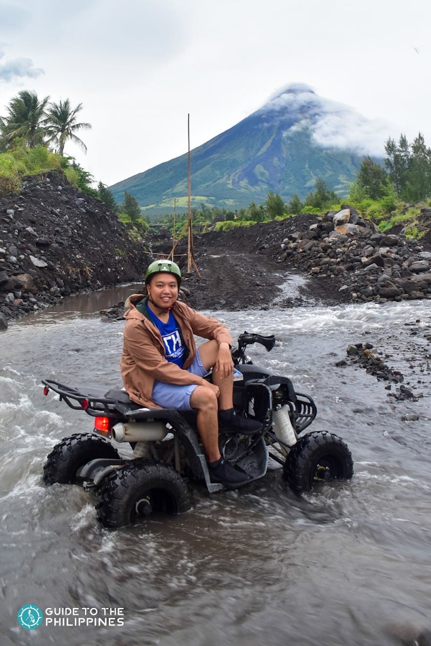 Traveler driving ATV across a river crossing