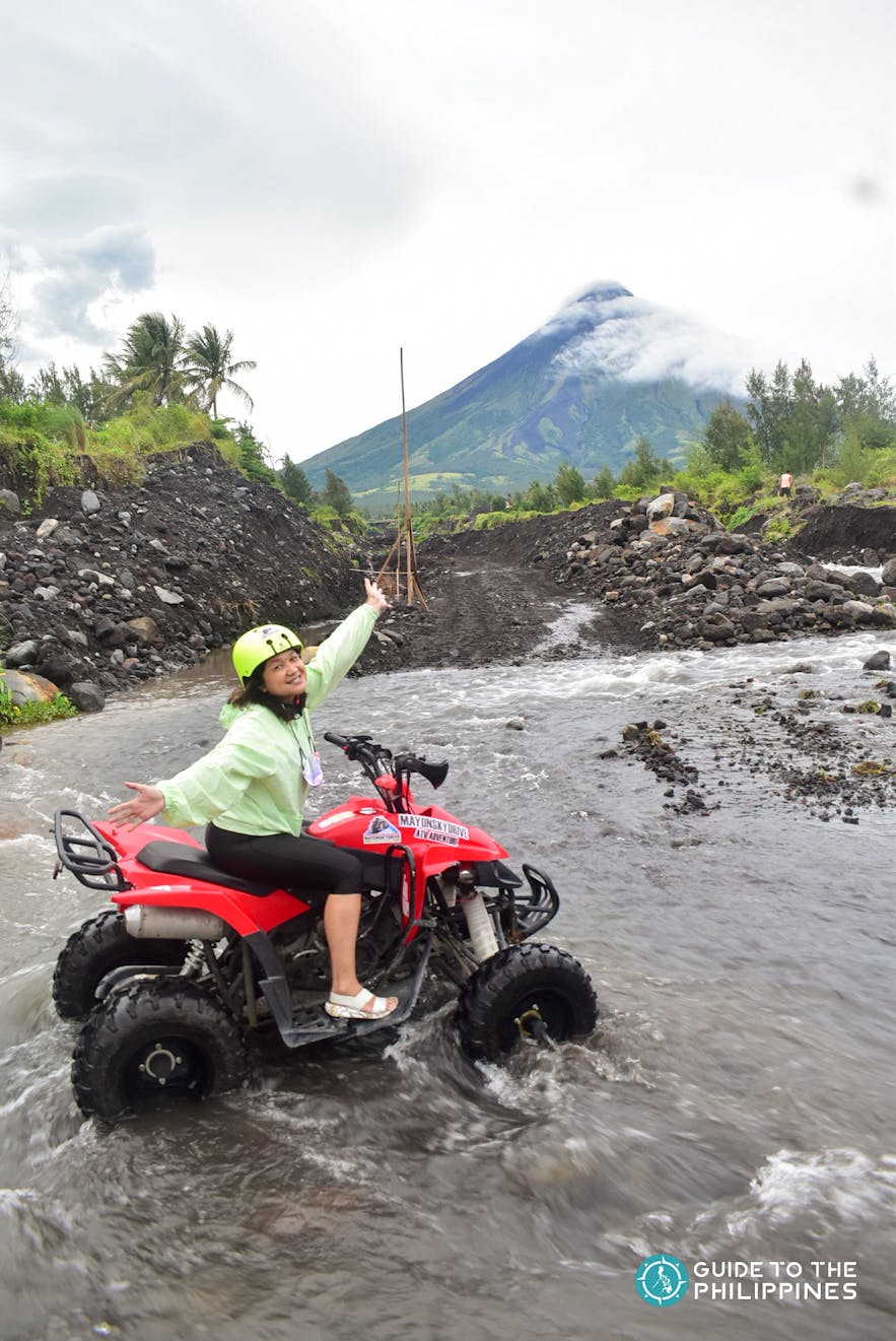Woman riding an ATV by Mayon Volcano