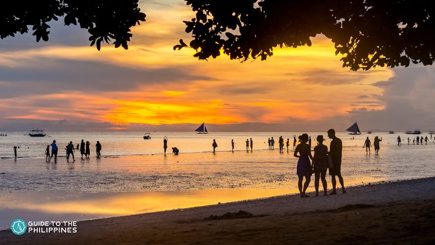 Tourists on White Beach watching the sunset