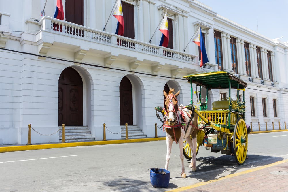 Riding the kalesa or horse-driven carriage in Intramuros, Manila, Philippines