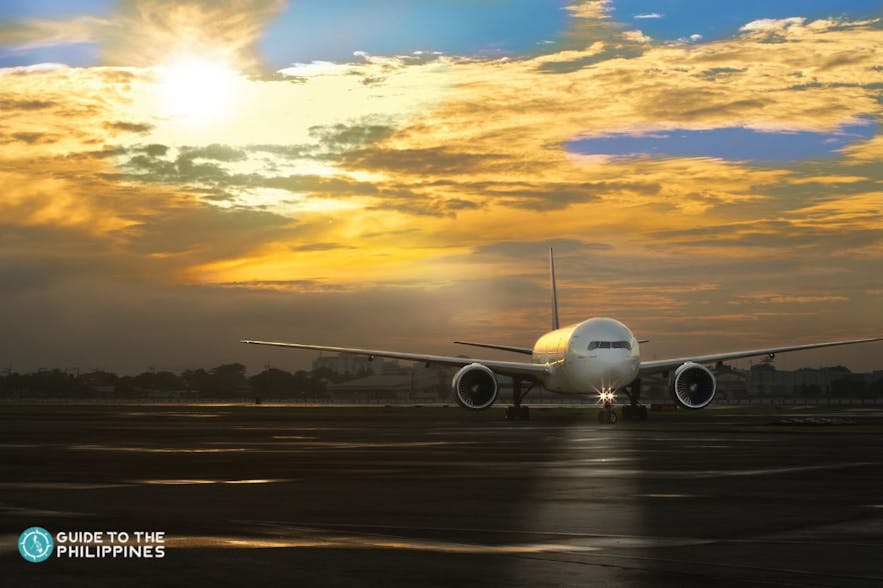 Plane lands in airport during sunset